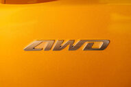 Emblema AWD na carroçaria amarela da KGM Musso EV