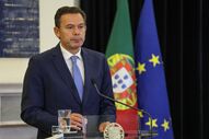 Figura pública discursa com as bandeiras de Portugal e da União Europeia ao fundo