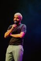 Humorista atua em palco com um microfone