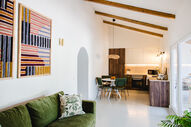 Sala de estar luminosa com cozinha aberta e decoração moderna
