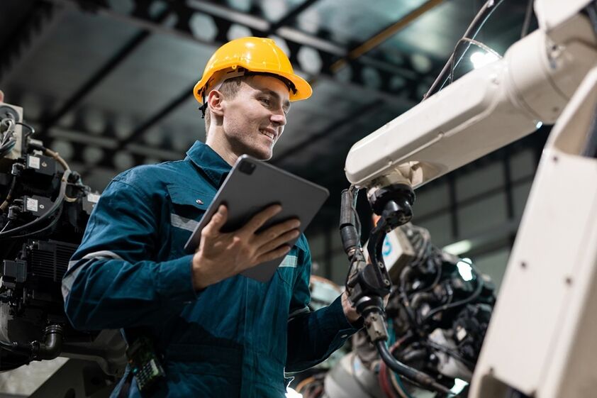Operário usa tablet para controlar robô industrial na Webcomum