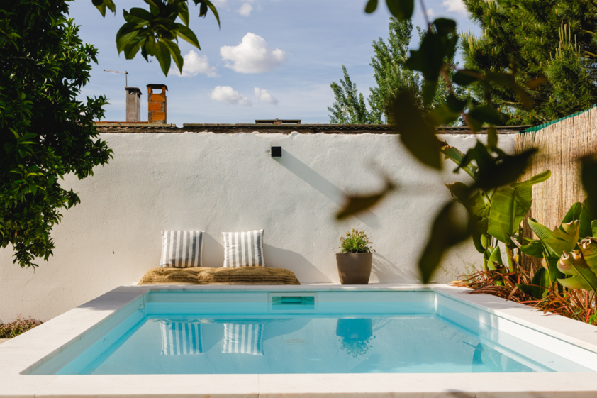 Piscina calma com almofadas e plantas num ambiente relaxante