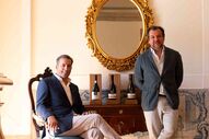 Dois homens posam ao lado de garrafas de vinho Costa Boal Douro
