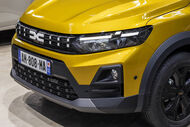 Detalhe frontal de um Dacia amarelo com matrícula visível