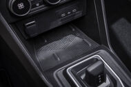 Detalhe do interior de um veículo com carregador sem fios e portas USB
