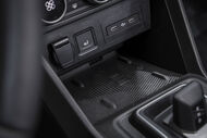 Detalhe do interior de um carro, com foco nas portas USB e no botão do assento