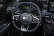 Interior de um carro com volante e painel da Dacia