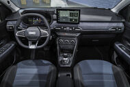 Interior de um Dacia com ecrã de navegação e assentos modernos