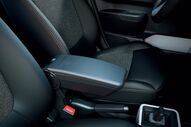 Interior do Dacia Spring, com foco no apoio de braço e nos bancos em tons de cinza e preto