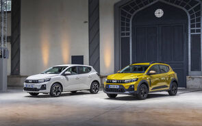 Dois carros Dacia Sandero em frente a um edifício industrial