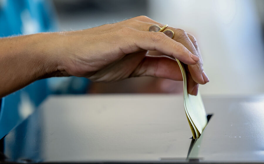 Mão deposita voto em urna eleitoral