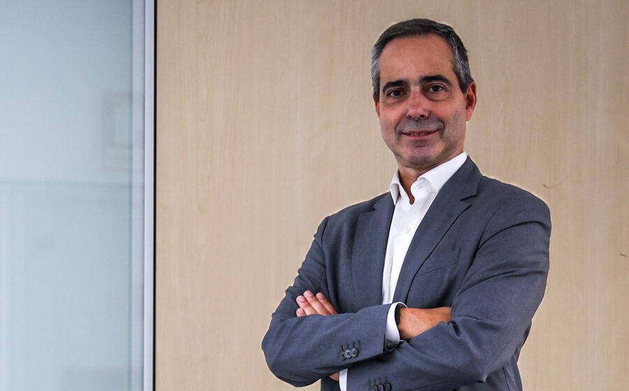 Um homem de fato posa com os braços cruzados