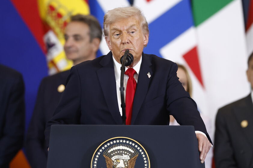 Donald Trump discursa num pódio com o selo presidencial