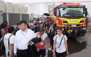 Bombeiros e voluntários num evento com o camião de bombeiros da Scania ao fundo