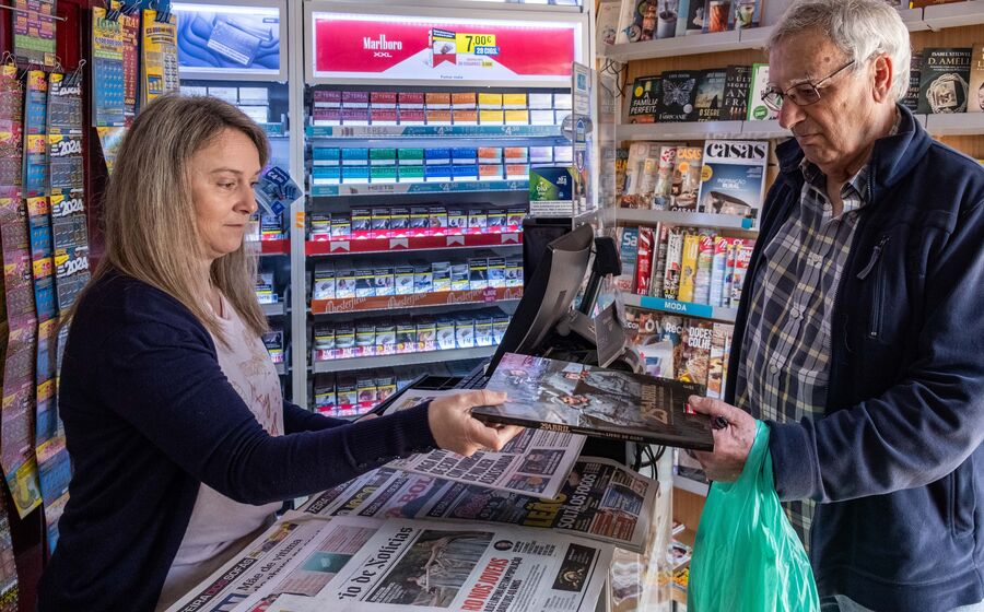 Cliente compra o livro '25 de Abril' numa papelaria com jornais em destaque
