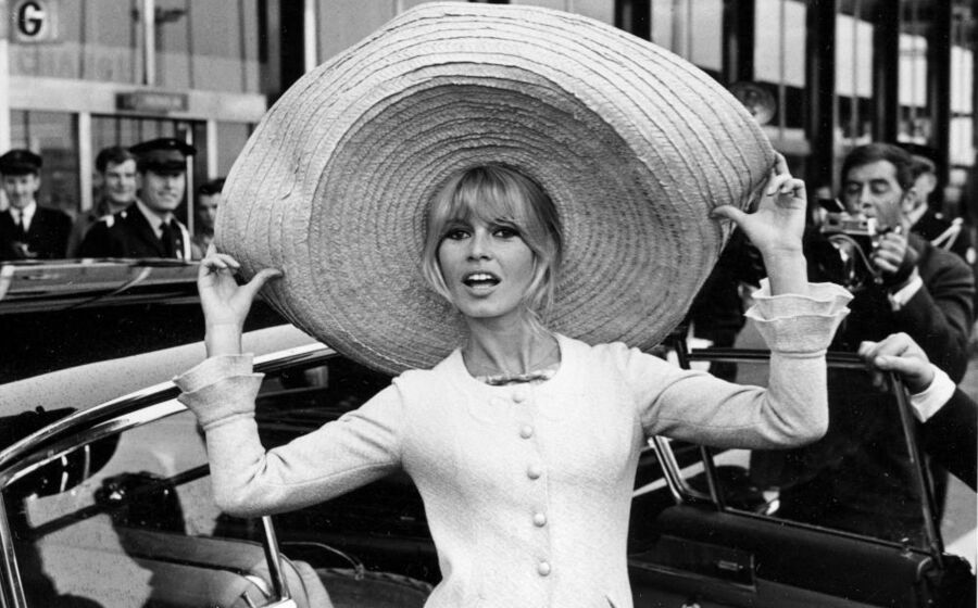 Brigitte Bardot posa com um enorme sombrero que trouxe do México, ao chegar ao Aeroporto de Orly, em Paris, França, a 27 de maio de 1965.