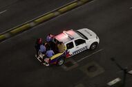 Carro da polícia venezuelana transporta pessoas em Caracas após anúncio de Trump sobre Maduro