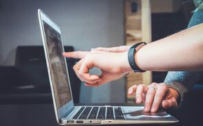 Mulher usa computador portátil com bracelete preta no pulso