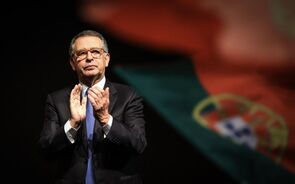 Marcelo Rebelo de Sousa aplaude em cerimónia com a bandeira de Portugal ao fundo