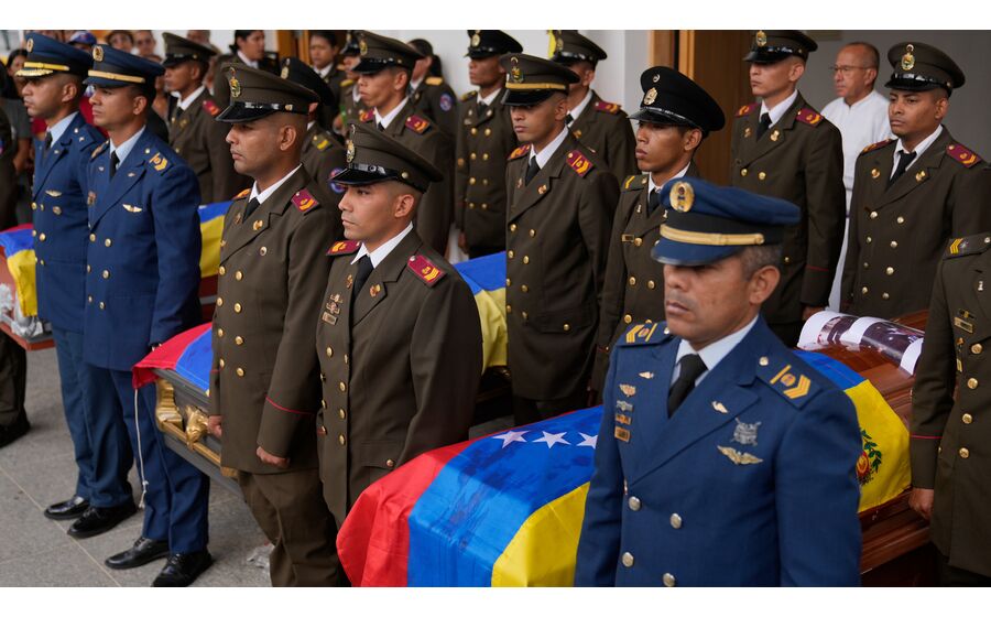 Cerimónia fúnebre com caixões cobertos com a bandeira venezuelana