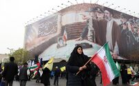 Uma mulher passa em frente de um cartaz com o novo líder supremo do Irão.