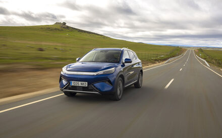 Um carro azul da BYD circula numa estrada rural