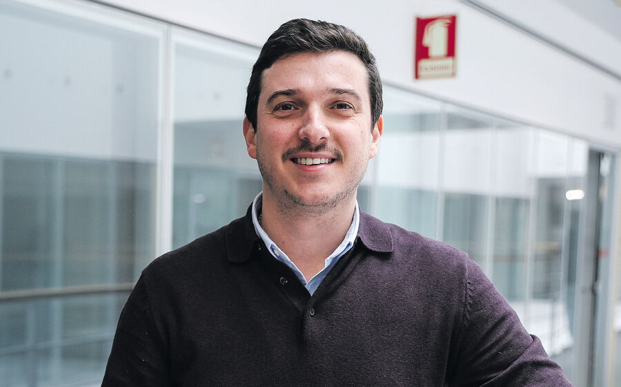 Retrato de um homem sorrindo para a câmara num edifício moderno