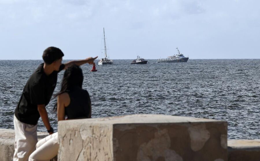 Pessoas vêem barcos aproximar-se de Havana, Cuba.