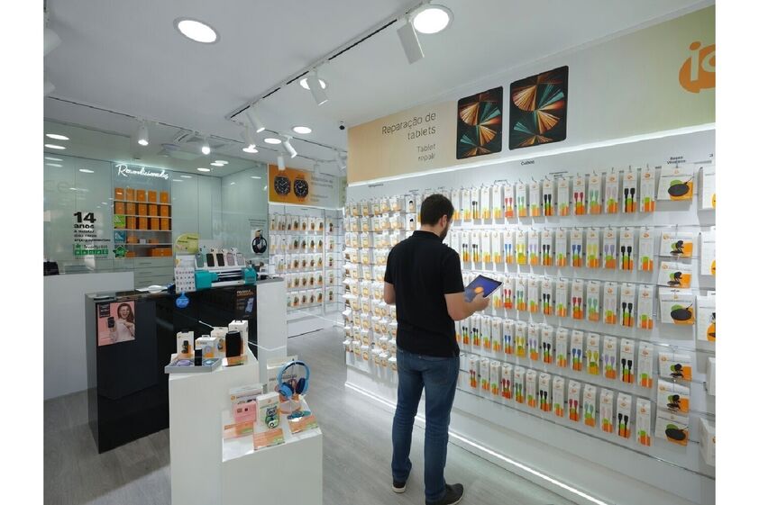 Homem consulta tablet em loja de reparação de tablets