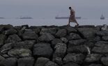 Um homem passa junto à costa do estreito de Ormuz, nos Emirados Árabes Unidos.