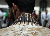 Um homem usa um cinto de balas ao pescoço num protesto anti-EUA e anti-Israel no Iémen.