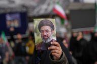 Um manifestante segura um retrato do líder iraniano Mojtaba Khamenei, após as notícias do cessar-fogo.