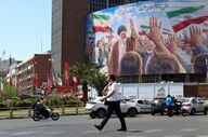Iranianos passam por um cartaz do antigo líder supremo, em Teerão.