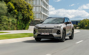 Automóvel Toyota a circular numa estrada perto de um edifício