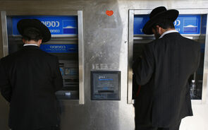 Dois judeus ortodoxos levantam dinheiro num ATM em Jerusalém