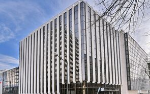 Edifício moderno com fachada em vidro e colunas verticais brancas