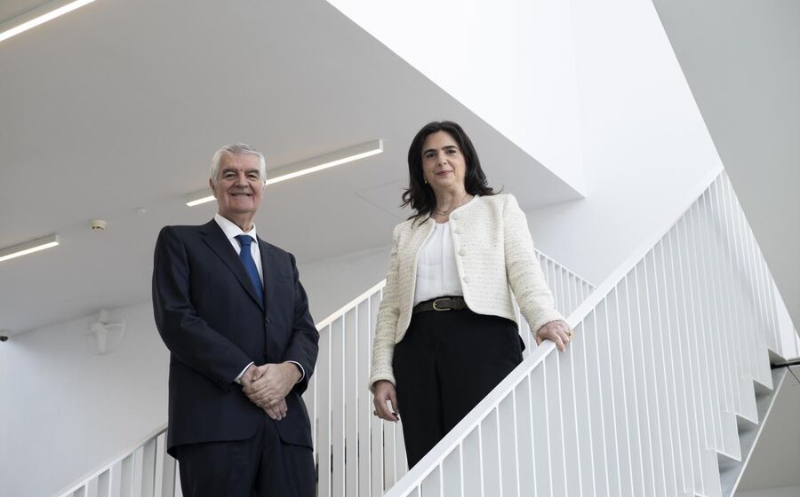 Dois executivos posam numa escadaria moderna