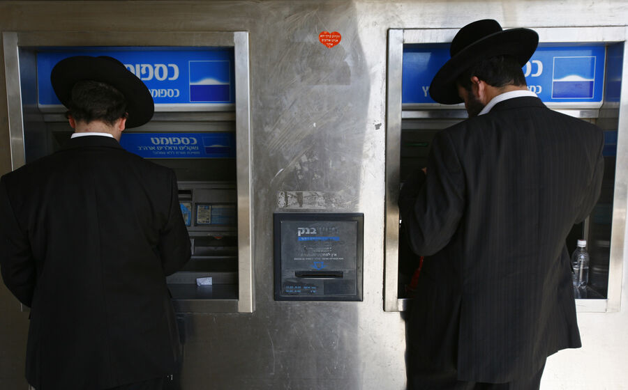 Dois judeus ortodoxos levantam dinheiro num ATM em Jerusalém