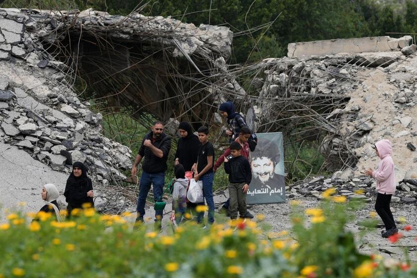 Famílias tentam atravessar uma ponde destruída no sul do Líbano.