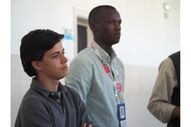 Pessoas assistem a evento com crachás identificativos