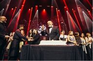 Celebração num evento com bolo e pessoas em palco
