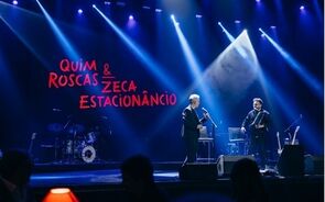 Concerto de Quim Roscas e Zeca Estacionâncio em palco com iluminação e banda