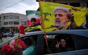 Naim Qassem, líder do Hezbollah, representado numa bandeira