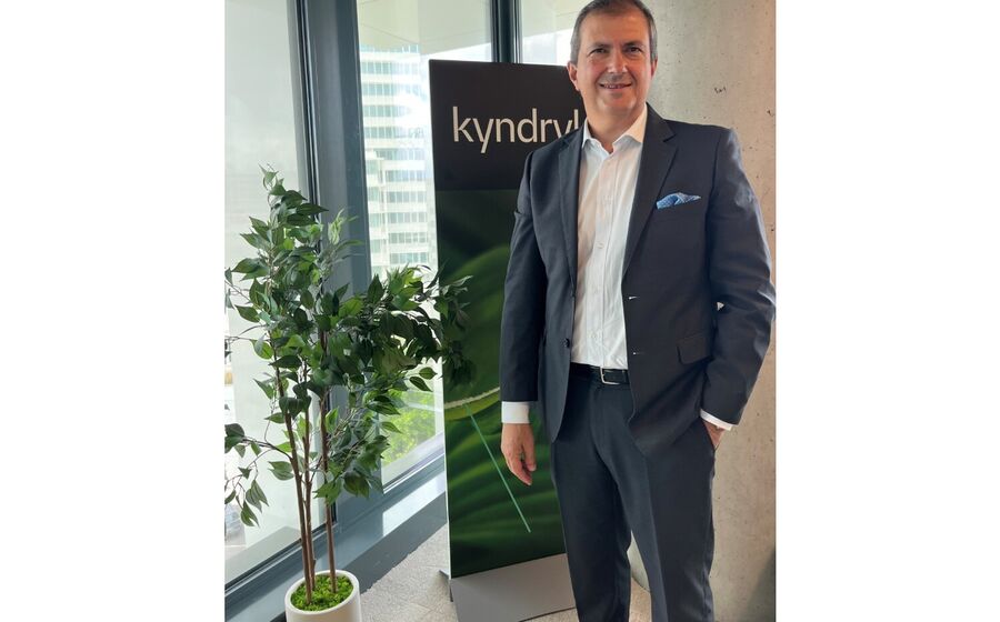 Um homem posa junto ao logótipo da Kyndryl