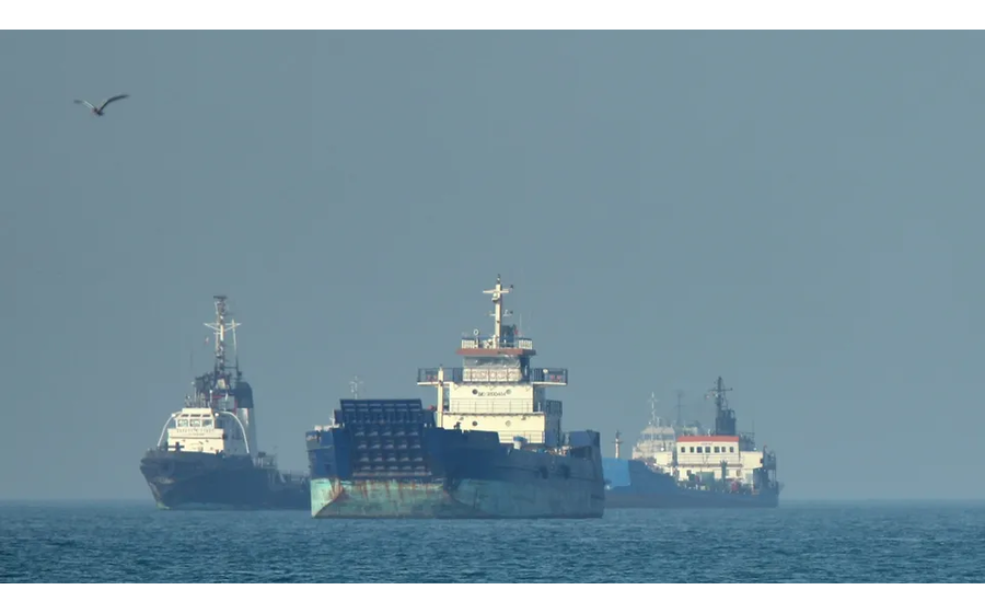 Embarcações navegam em mar calmo sob céu claro.
