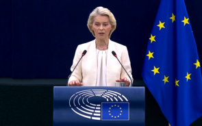 Ursula von der Leyen fala no Parlamento Europeu junto à bandeira da UE