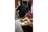 Chef corta leitão para clientes num festival gastronómico