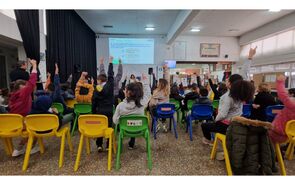 Alunos levantam a mão em sala com tema 'Stop Bullying'